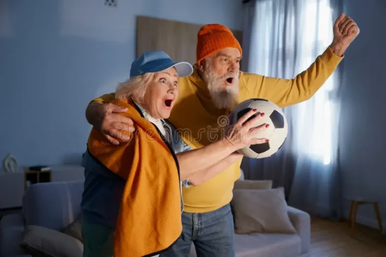 Laulātais pāris vēro futbola tiešraidi.